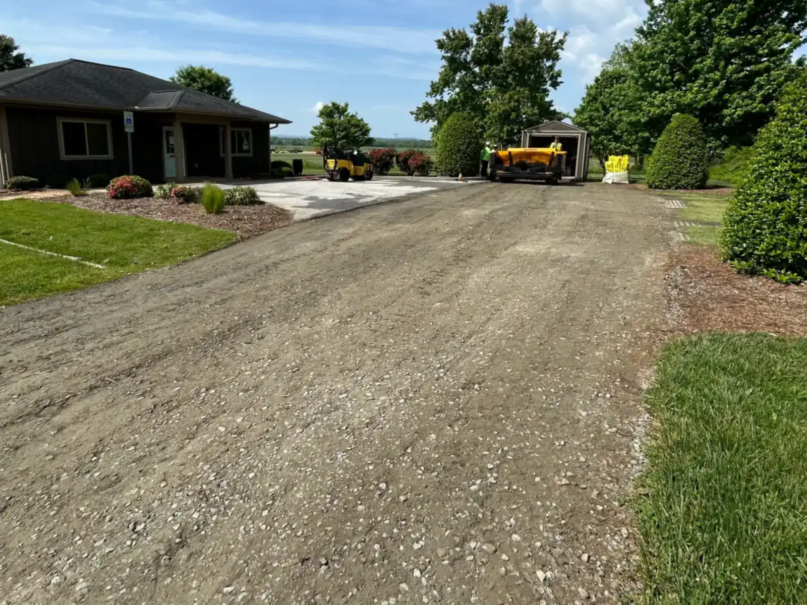 Before: rough, loose gravel driveway leading to a building